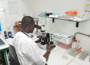 un technicien de labo regard dans le microscope